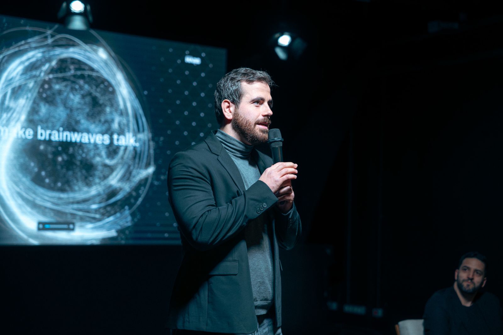 Douglas Moreau, microphone in hand, during a talk on neuroscience and artificial intelligence