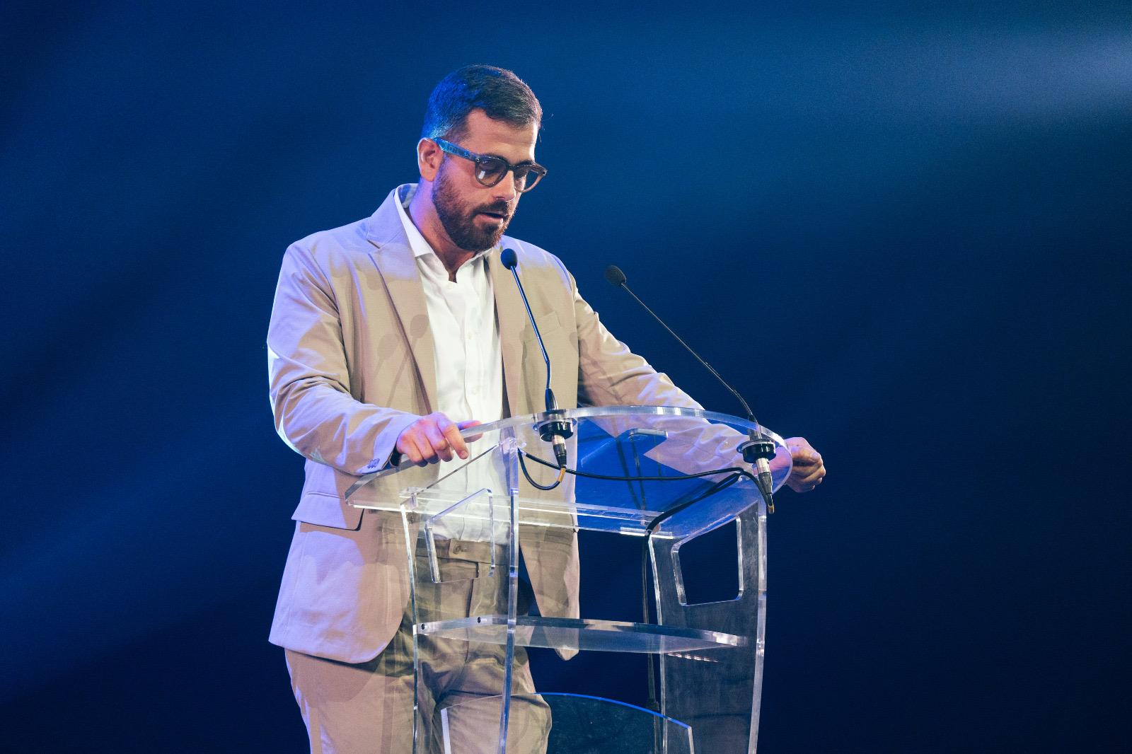 Douglas Moreau at the lectern on the stage of the Zénith de Paris